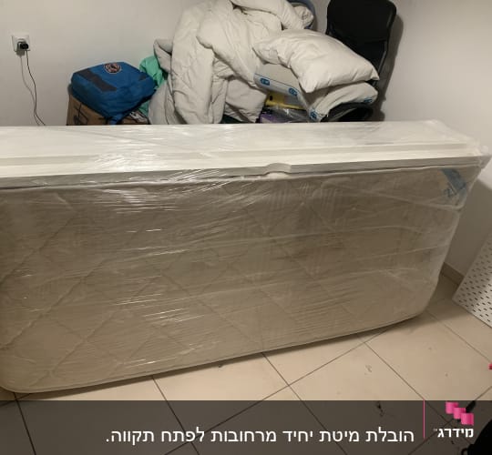 מזרן עטוף בניילון בחדר עם חפצים שונים